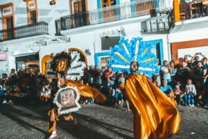 Vibrant street parade with colorful costumes and dancers in Puerto Vallarta, Mexico.