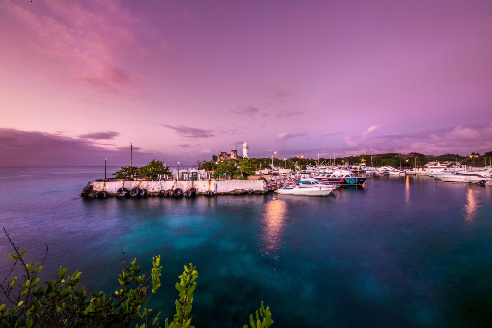 Vibrant and serene harbor in San Miguel de Cozumel, Mexico during sunset with boats moored peacefully.