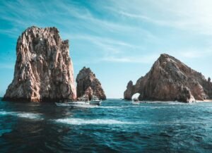 Stunning Cabo San Lucas seascape with rock formations and boats on a clear day.