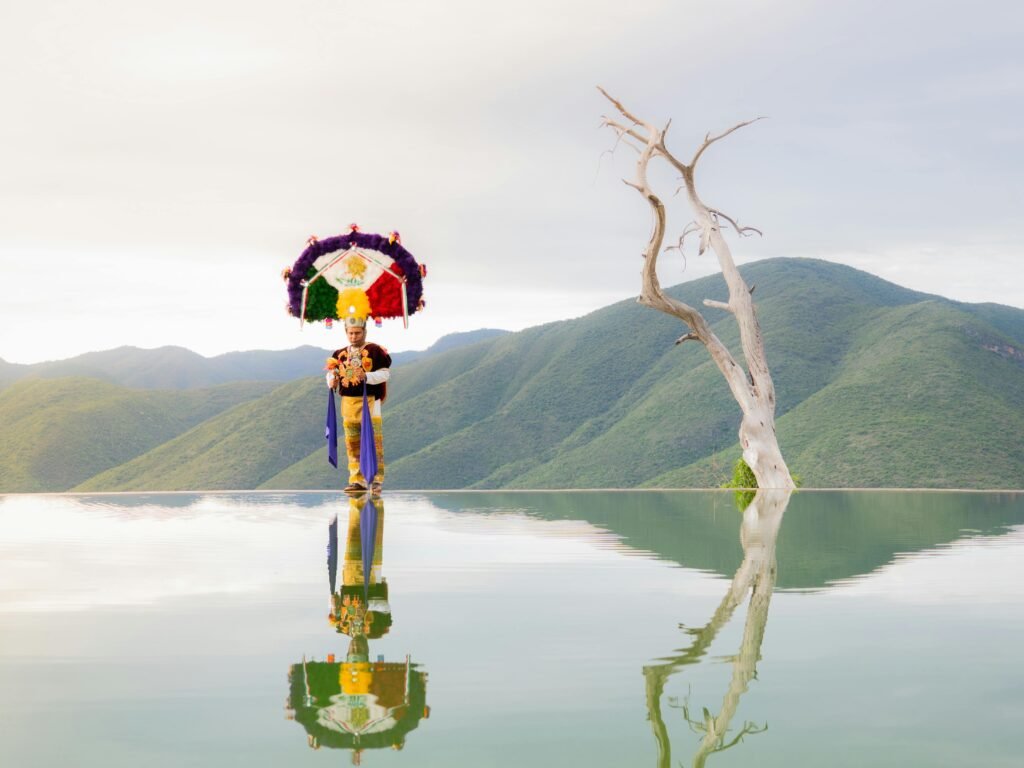 Traditional dancer reflects at Hierve el Agua in Oaxaca, capturing cultural essence and natural beauty.