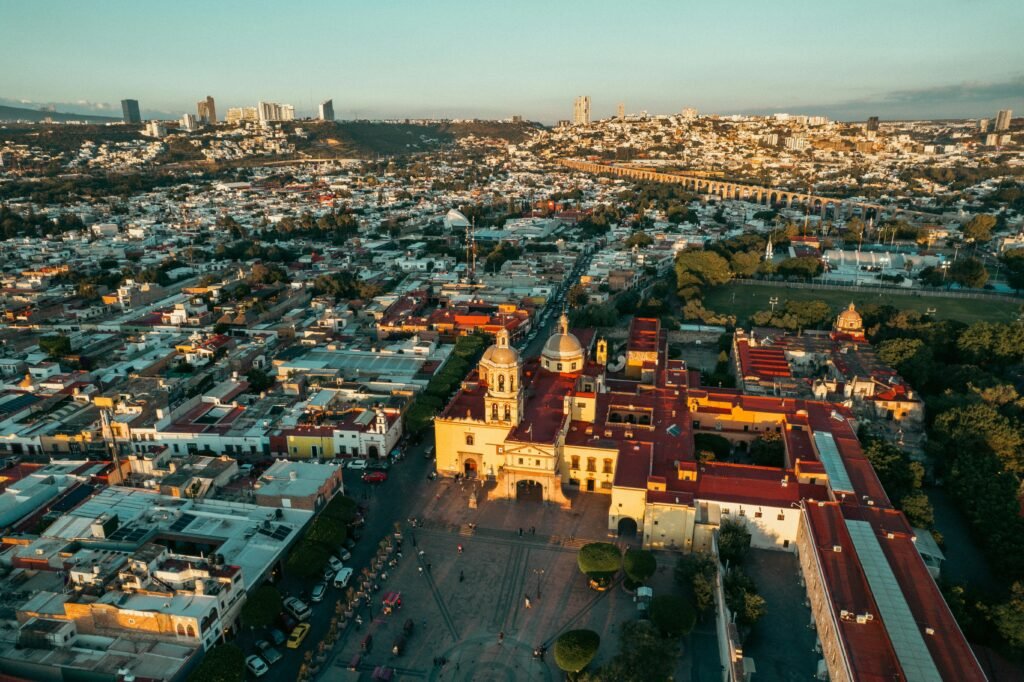 A stunning aerial view of Querétaro's historic district at sunset, featuring vibrant architecture and cityscape.
