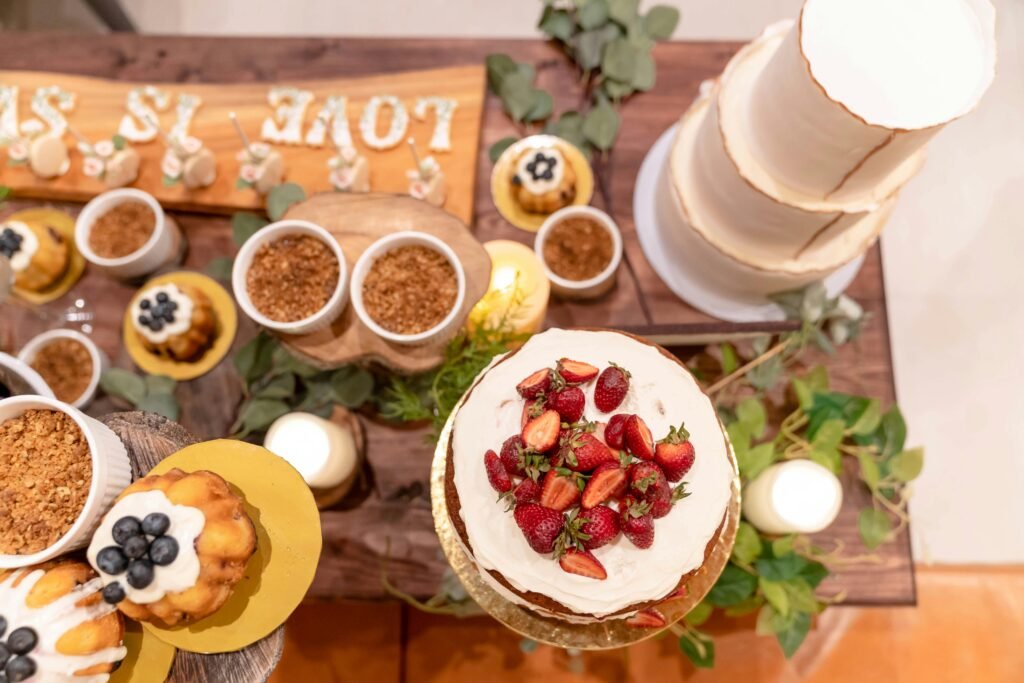 Top view of a wedding dessert table featuring a styled cake with strawberries and assorted pastries.